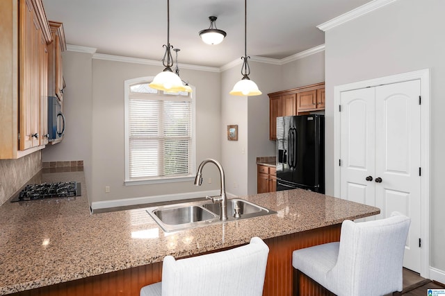 kitchen featuring pendant lighting, black appliances, crown molding, sink, and kitchen peninsula