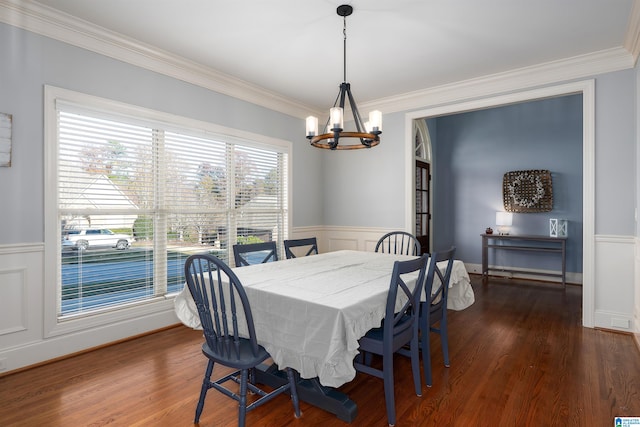 dining area with dark hardwood / wood-style floors, an inviting chandelier, and ornamental molding