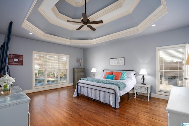 bedroom featuring ceiling fan, wood-type flooring, and multiple windows