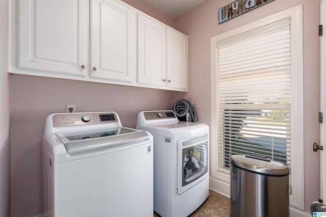 washroom featuring washer and clothes dryer and cabinets