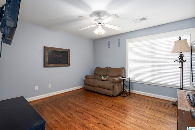 living area featuring ceiling fan and hardwood / wood-style flooring