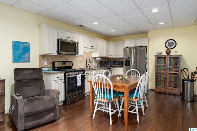 kitchen with dark hardwood / wood-style flooring, stainless steel appliances, white cabinetry, and sink