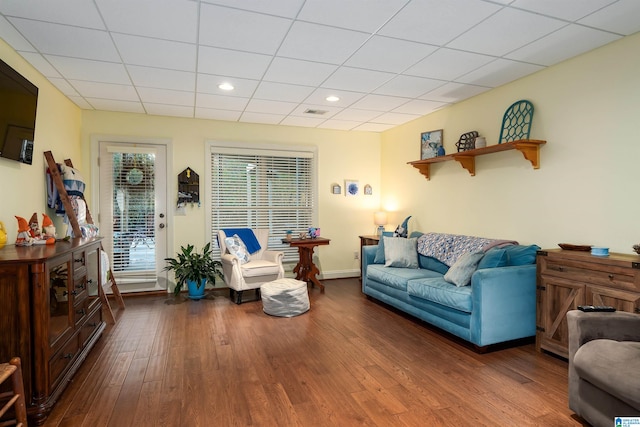 living room featuring dark hardwood / wood-style flooring and a paneled ceiling