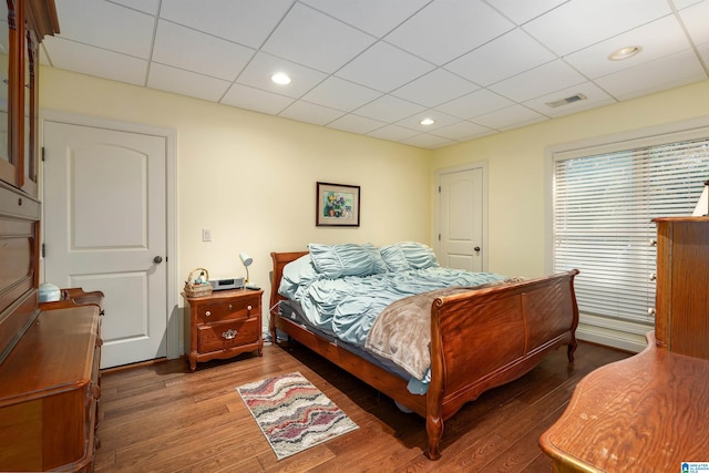 bedroom with dark hardwood / wood-style flooring and a paneled ceiling