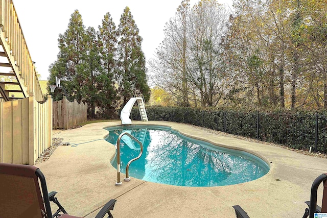 view of swimming pool featuring a patio and a water slide