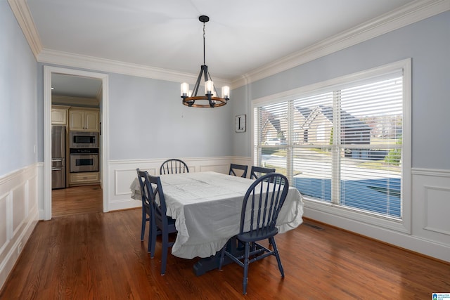 dining space featuring ornamental molding, dark wood-type flooring, and a notable chandelier