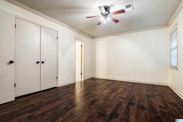 unfurnished bedroom with dark hardwood / wood-style flooring, a closet, ceiling fan, and crown molding