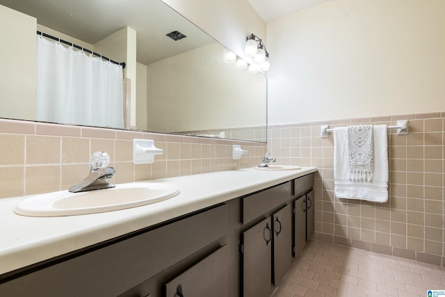 bathroom with tile patterned flooring, vanity, and tile walls