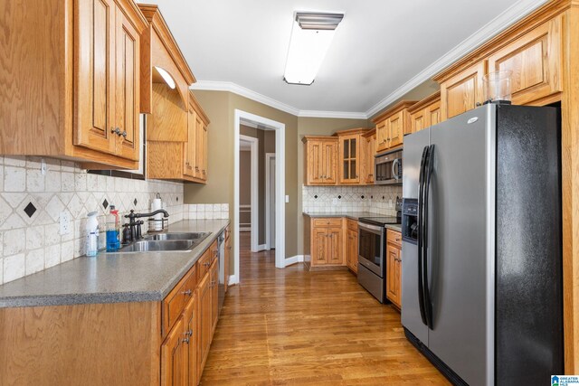 175 Smithfield Ln, Springville, AL 35146 - kitchen featuring appliances with stainless steel finishes, a sink, light wood finished floors, ornamental molding, and backsplash