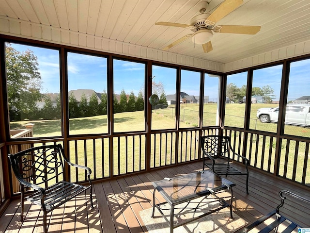 unfurnished sunroom featuring plenty of natural light, wooden ceiling, and ceiling fan