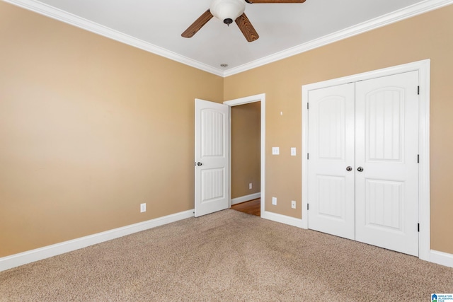 unfurnished bedroom featuring carpet flooring, ceiling fan, a closet, and ornamental molding