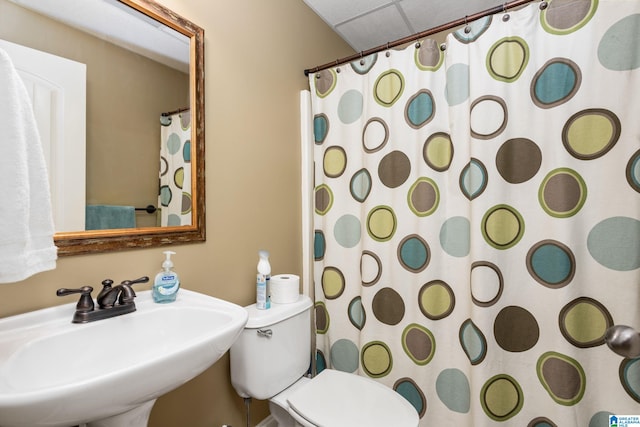 bathroom with toilet, curtained shower, and sink