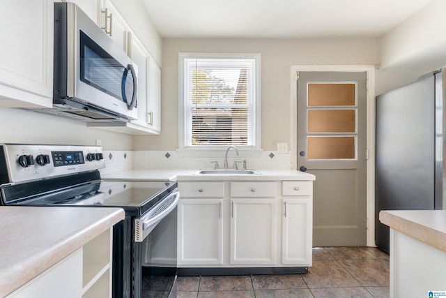 kitchen featuring white cabinets, light tile patterned flooring, sink, and stainless steel appliances