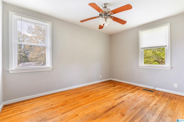 empty room with light wood-type flooring, ceiling fan, and a healthy amount of sunlight