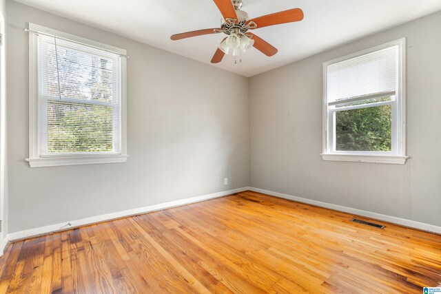 empty room featuring ceiling fan, light hardwood / wood-style flooring, and a healthy amount of sunlight