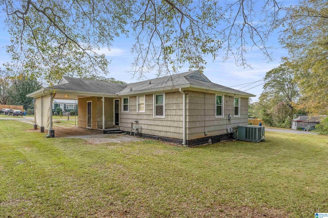 rear view of house with a carport, a yard, and cooling unit