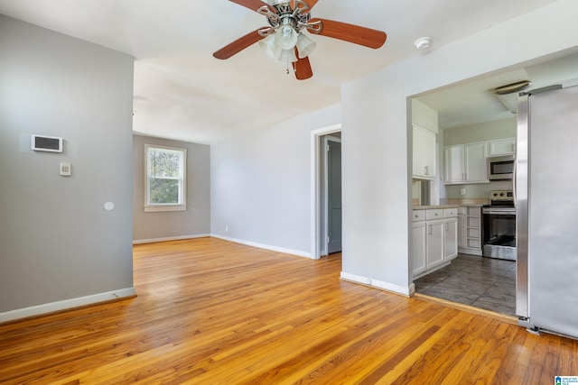 unfurnished living room featuring ceiling fan and light hardwood / wood-style flooring