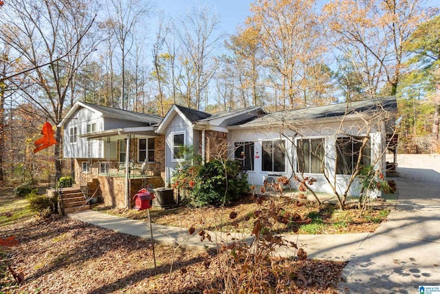 6879 Deer Haven Rd, Pinson, AL 35126 - view of front of home featuring covered porch, brick siding, a sunroom, stairs, and central AC