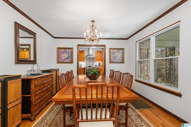 dining room featuring hardwood / wood-style flooring, ornamental molding, and an inviting chandelier