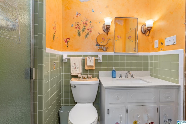 bathroom with vanity, toilet, tile walls, and a shower with shower door