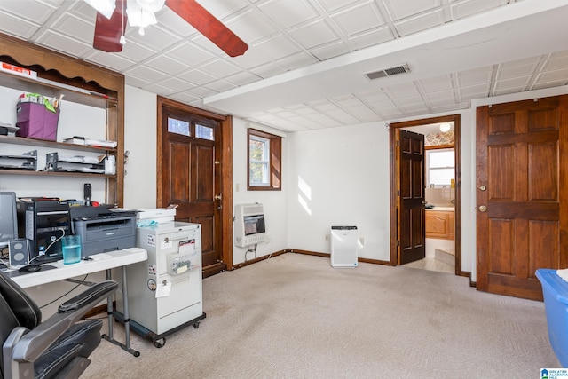 unfurnished office with heating unit, ceiling fan, and light colored carpet