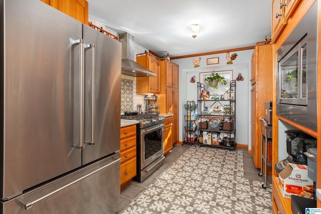 kitchen with decorative backsplash, ornamental molding, wall chimney range hood, and premium appliances