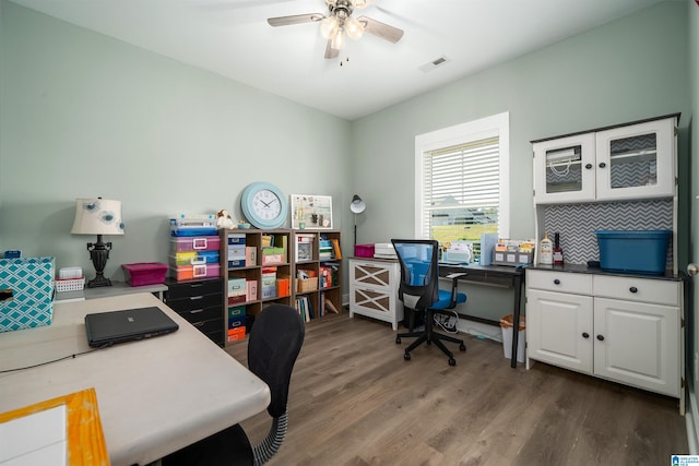 home office with dark hardwood / wood-style flooring and ceiling fan