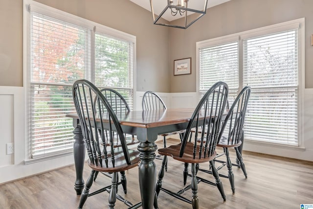 dining room with a healthy amount of sunlight, an inviting chandelier, and light hardwood / wood-style flooring