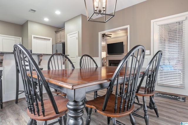 dining space featuring ceiling fan with notable chandelier and light hardwood / wood-style flooring