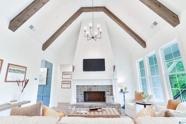 living room featuring a fireplace, light hardwood / wood-style floors, high vaulted ceiling, and a chandelier