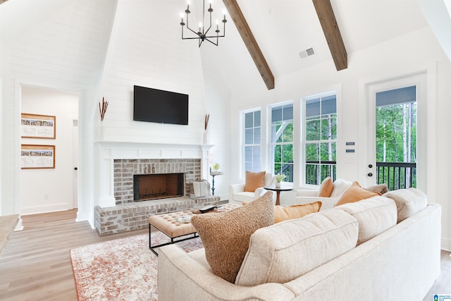 living room with a brick fireplace, light hardwood / wood-style flooring, high vaulted ceiling, and plenty of natural light