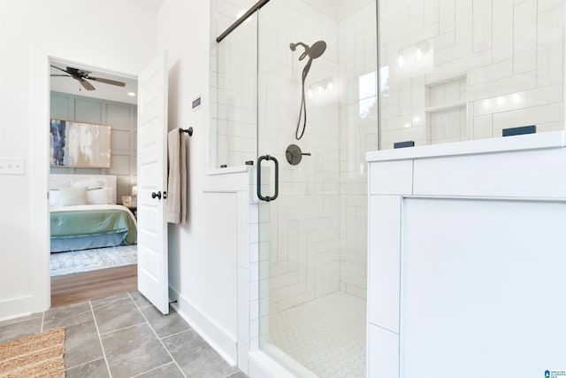 bathroom with hardwood / wood-style flooring, ceiling fan, and a shower with shower door