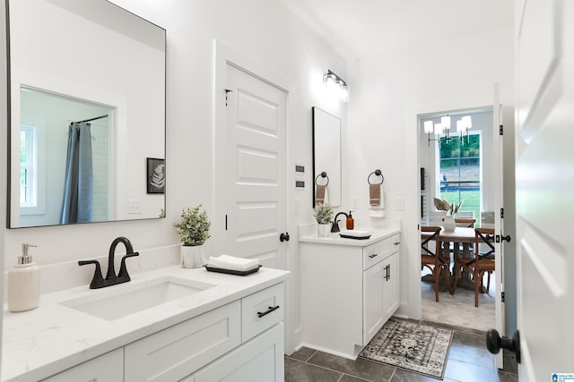 bathroom featuring tile patterned flooring, vanity, and a chandelier