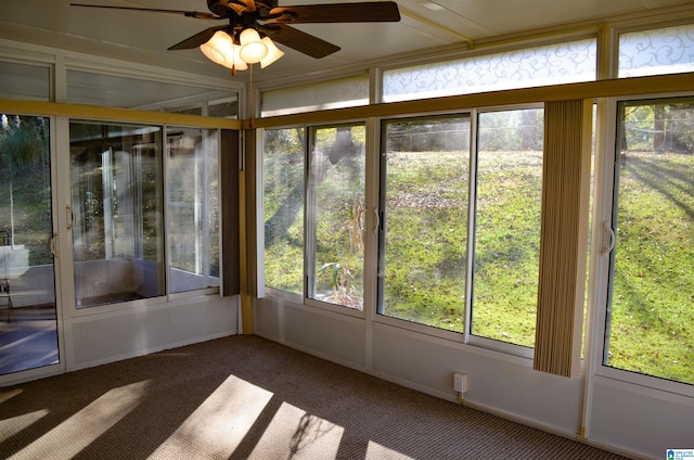 unfurnished sunroom featuring ceiling fan