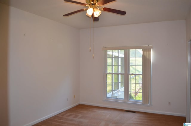 carpeted spare room with ceiling fan