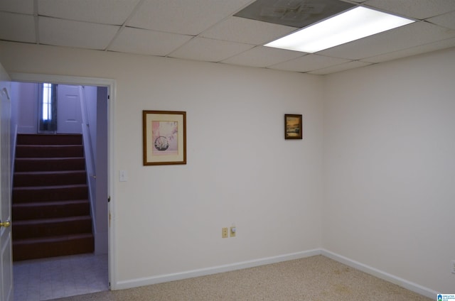 basement featuring carpet and a paneled ceiling