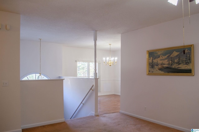 carpeted empty room featuring a chandelier and a wealth of natural light