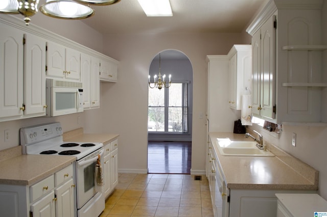 kitchen with white cabinetry, sink, white appliances, and an inviting chandelier