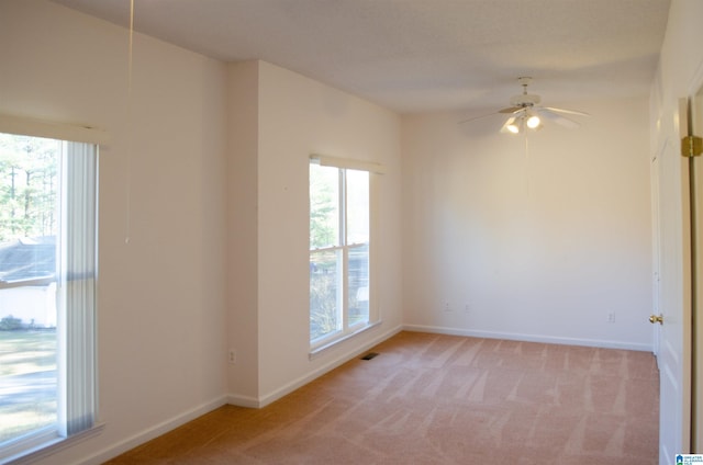 empty room featuring light colored carpet and ceiling fan