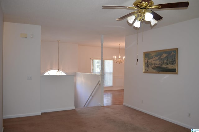 carpeted empty room featuring a chandelier