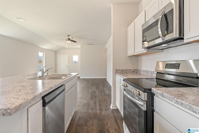 kitchen with appliances with stainless steel finishes, white cabinetry, dark wood-type flooring, and sink