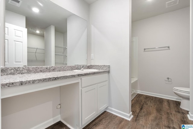 full bathroom featuring plus walk in shower, vanity, wood-type flooring, and toilet