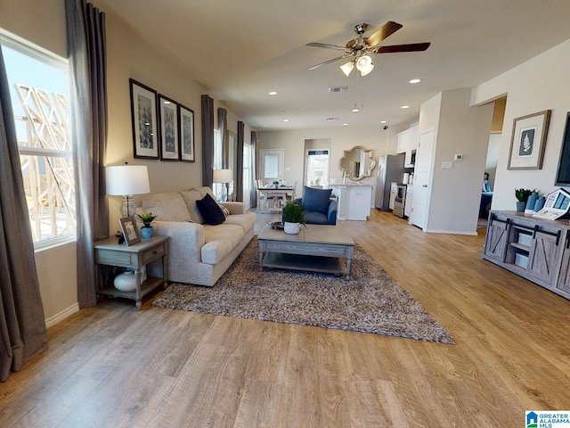 living room featuring light hardwood / wood-style floors and ceiling fan