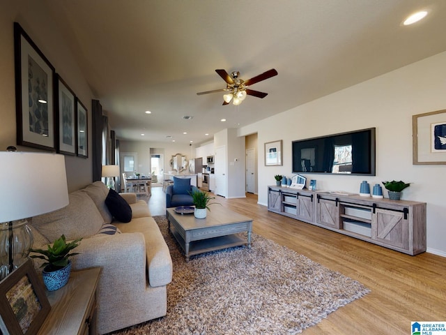 living room featuring ceiling fan and light wood-type flooring