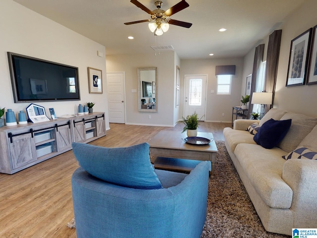 living room with light wood-type flooring and ceiling fan