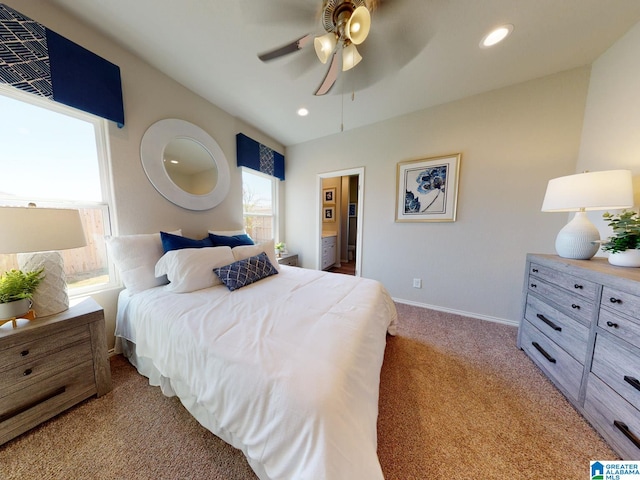 bedroom with connected bathroom, light colored carpet, and ceiling fan