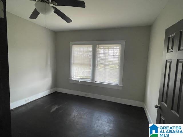 spare room featuring ceiling fan and dark hardwood / wood-style floors