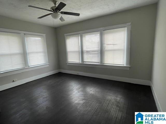 unfurnished room with dark hardwood / wood-style floors, ceiling fan, and a textured ceiling