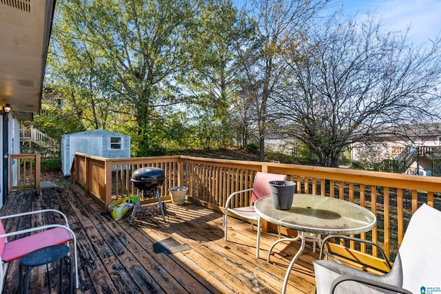 wooden terrace with a grill and a storage shed