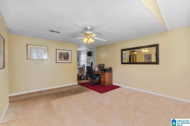 office area featuring ceiling fan, carpet floors, and a textured ceiling